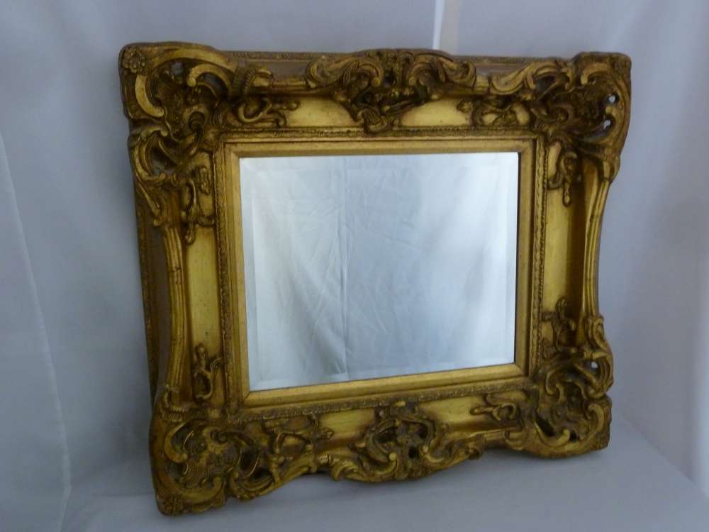 A rectangular wall mirror in ornate gilt frame