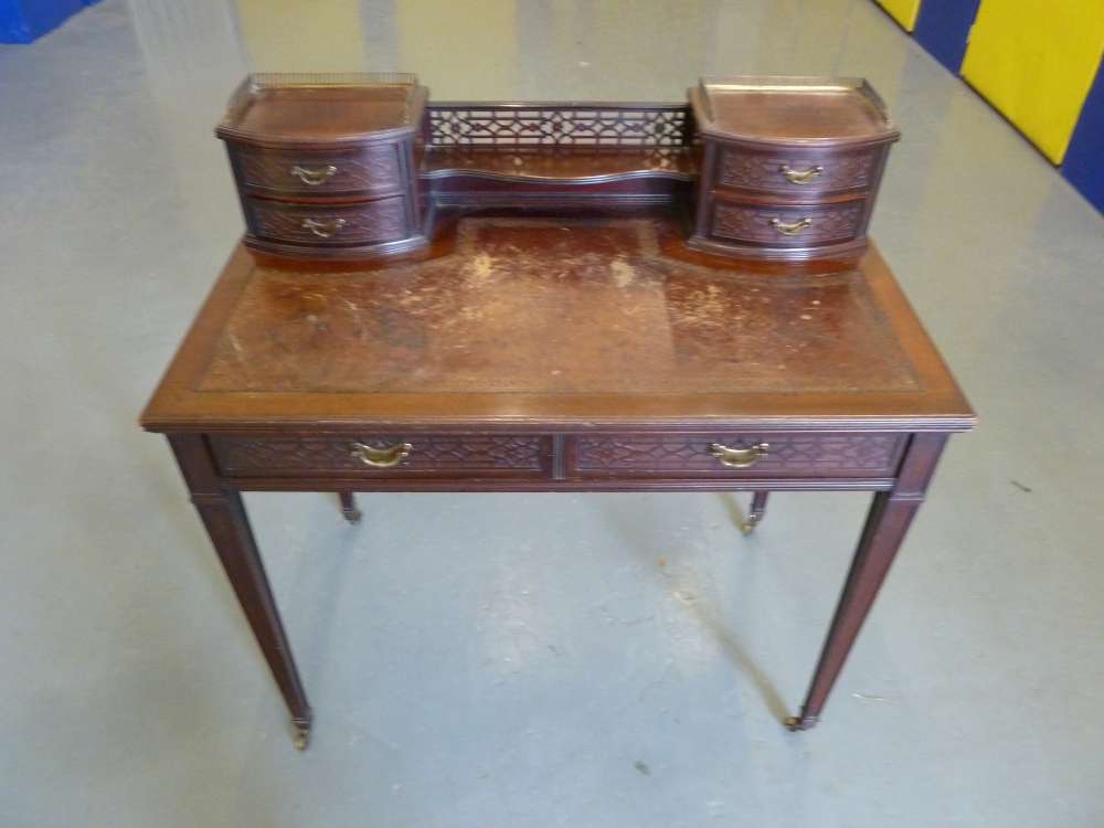 A rectangular mahogany desk with pierced gallery, leather inset, two drawers on four tapering