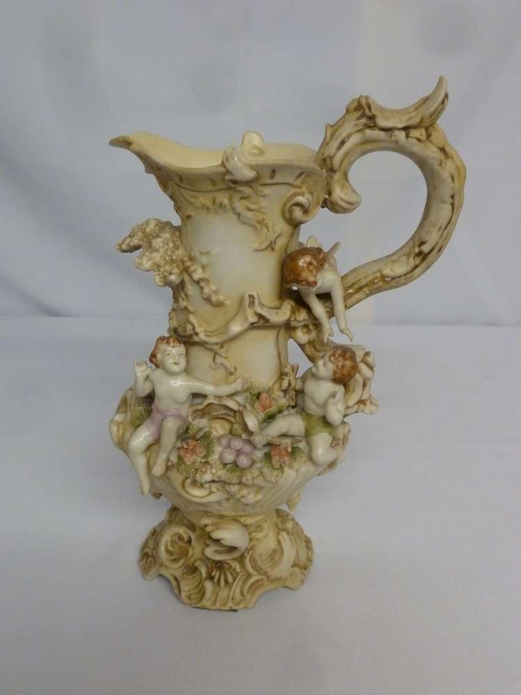 Continental porcelain ewer with applied putti, fruits and shells