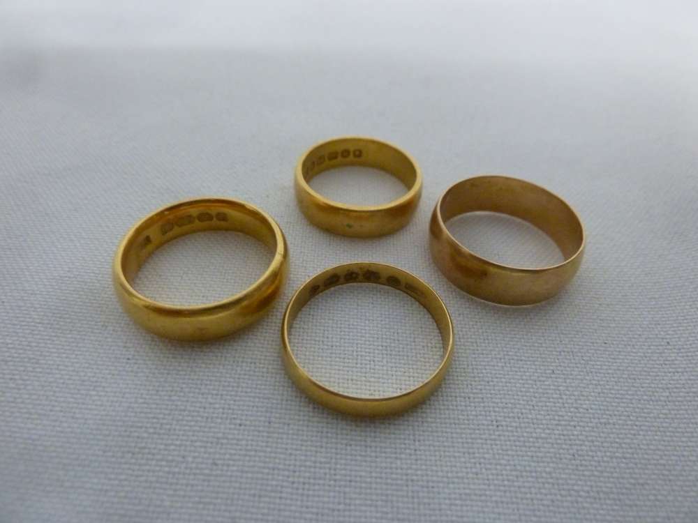 Four 22 ct gold wedding bands