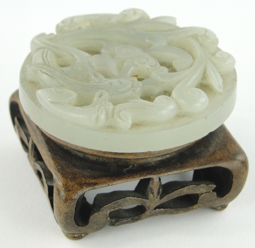 A Chinese carved and pierced jade buckle, 2.25" across.