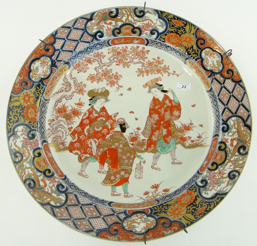 A large Chinese Imari charger with design of figures in a garden, finished in gold, with 4 character