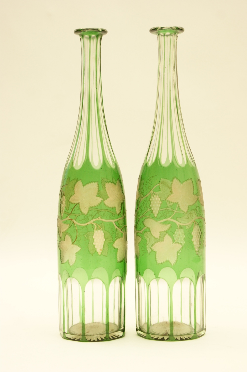 Pair of Bohemian green overlay engraved glass decanters, engraved with trailing vines (no stoppers),