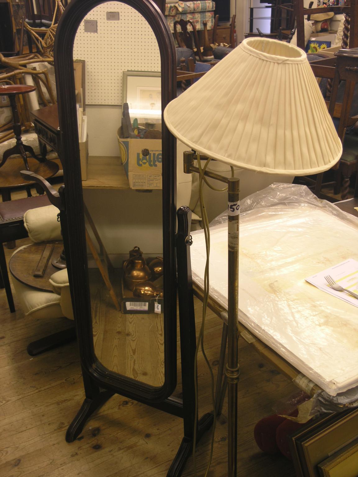 A brass floor lamp, with adjustable shade and a Victorian-style cheval mirror