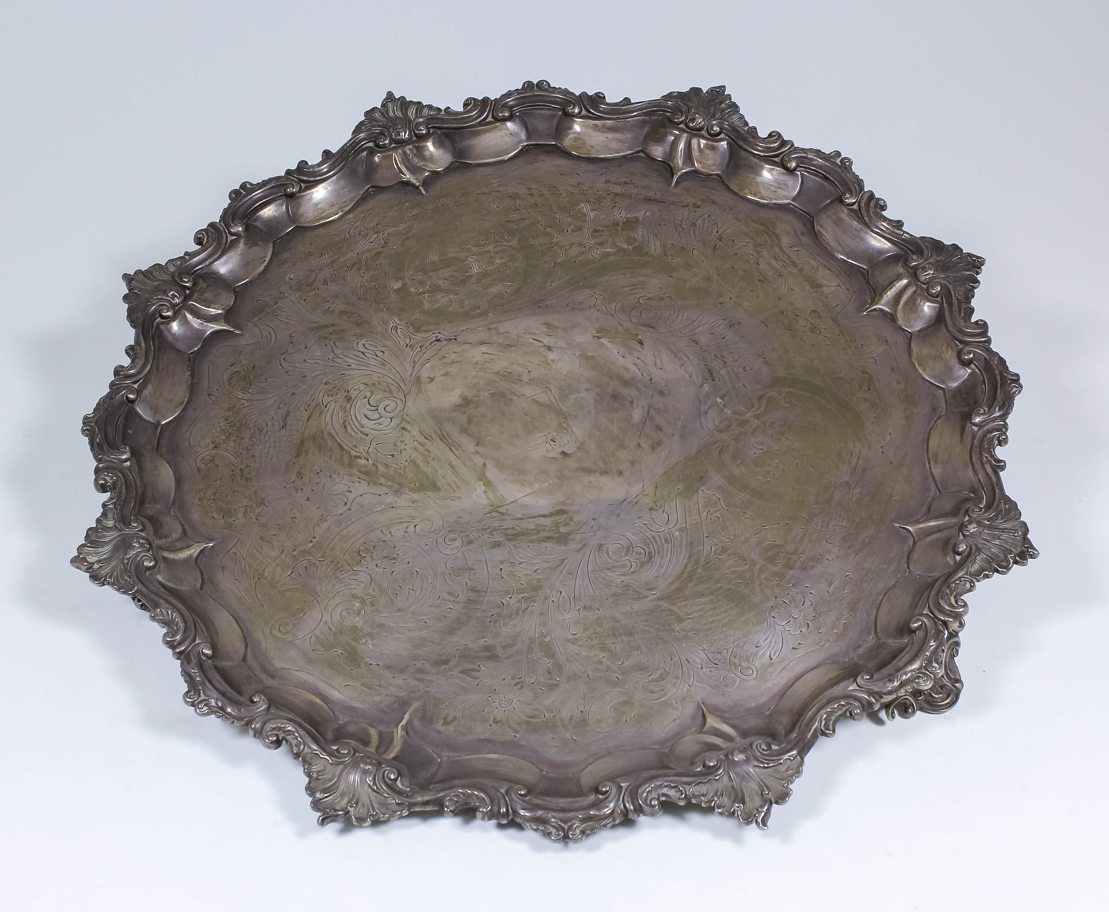 A William IV silver circular salver, the shaped rim with bold cast leaf, S and C-scroll mounts, the
