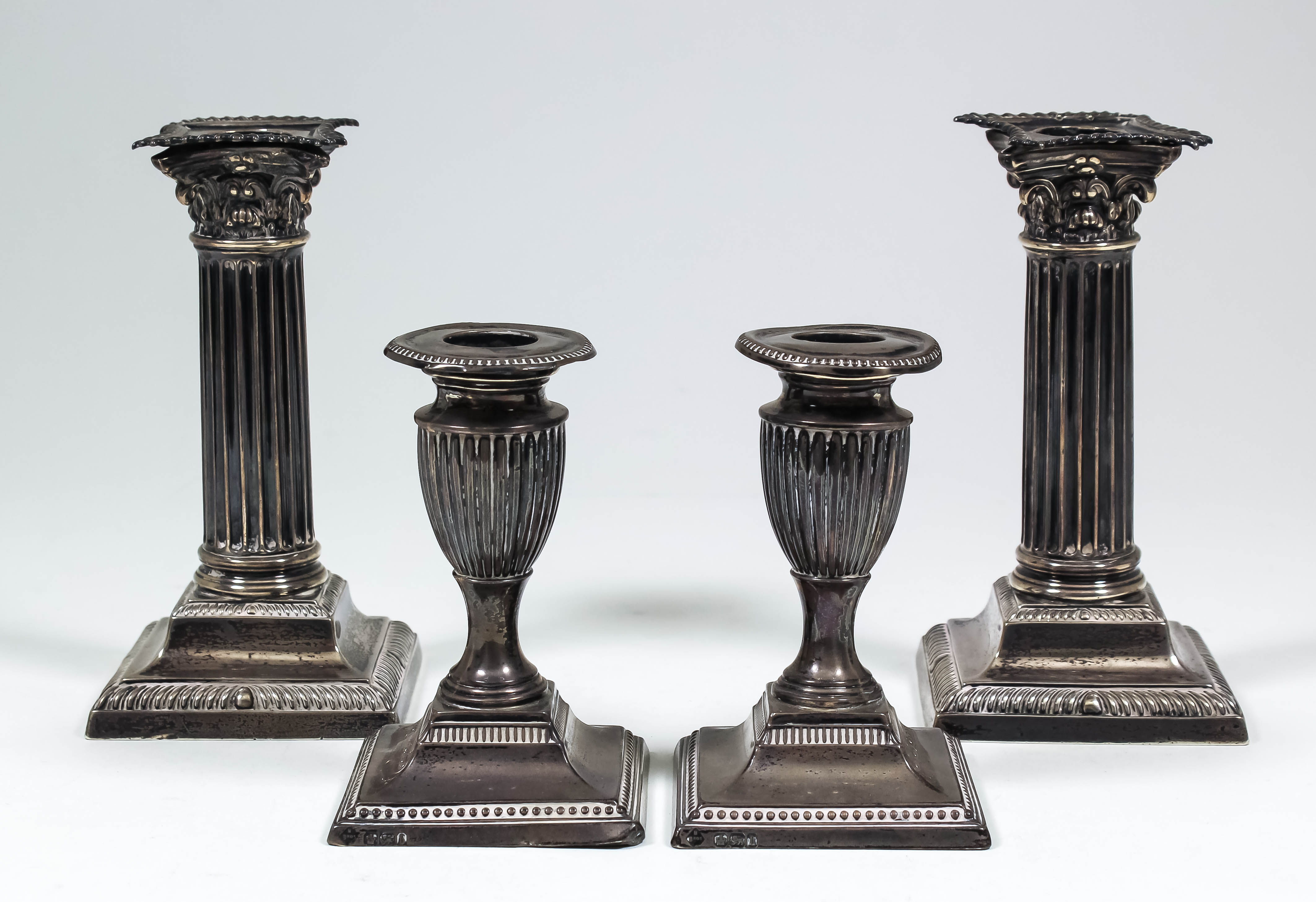 A pair of late Victorian silver pillar candlesticks of Corinthian column pattern, on square stepped