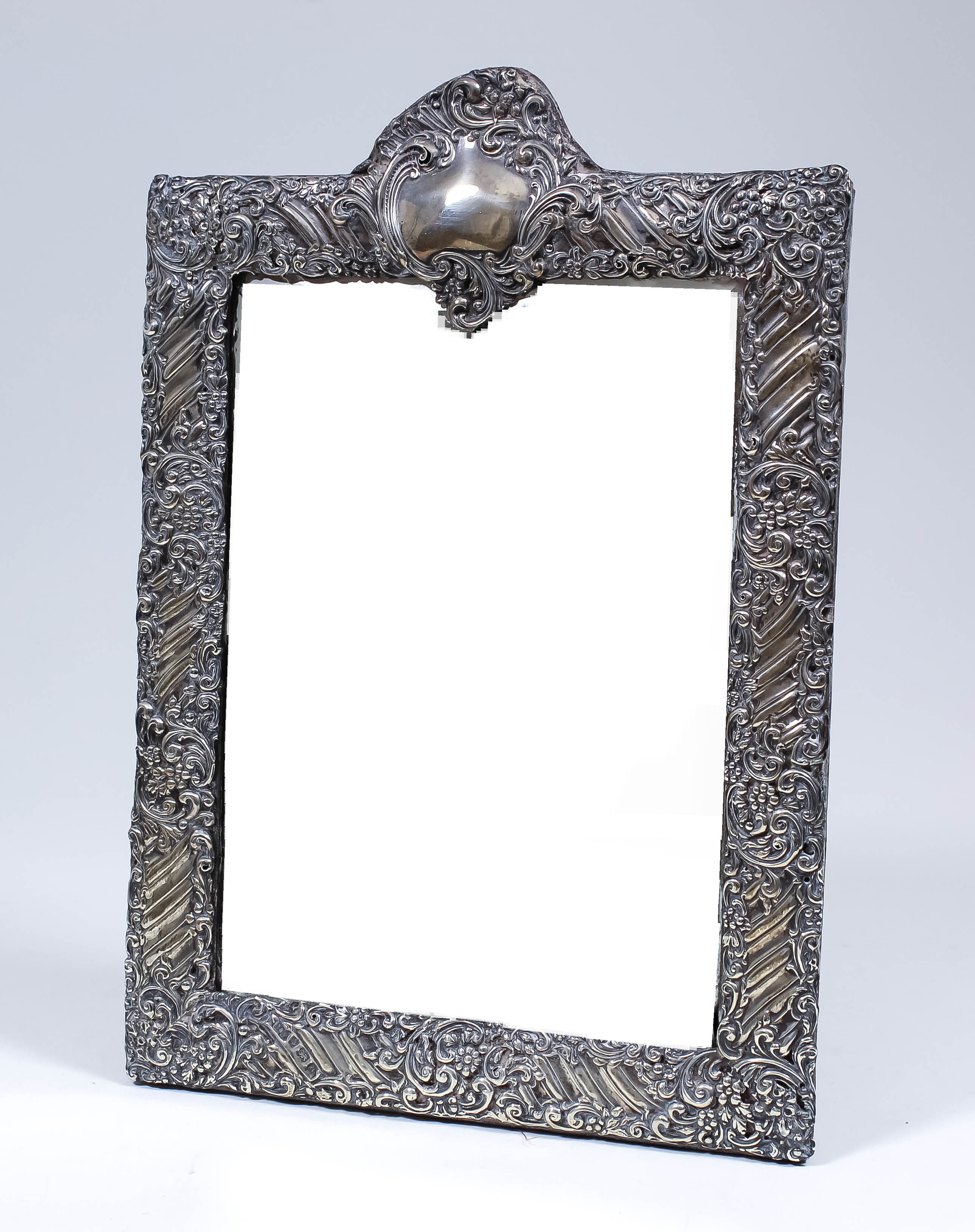 A late Victorian silver framed rectangular dressing table mirror embossed with leaf scroll and