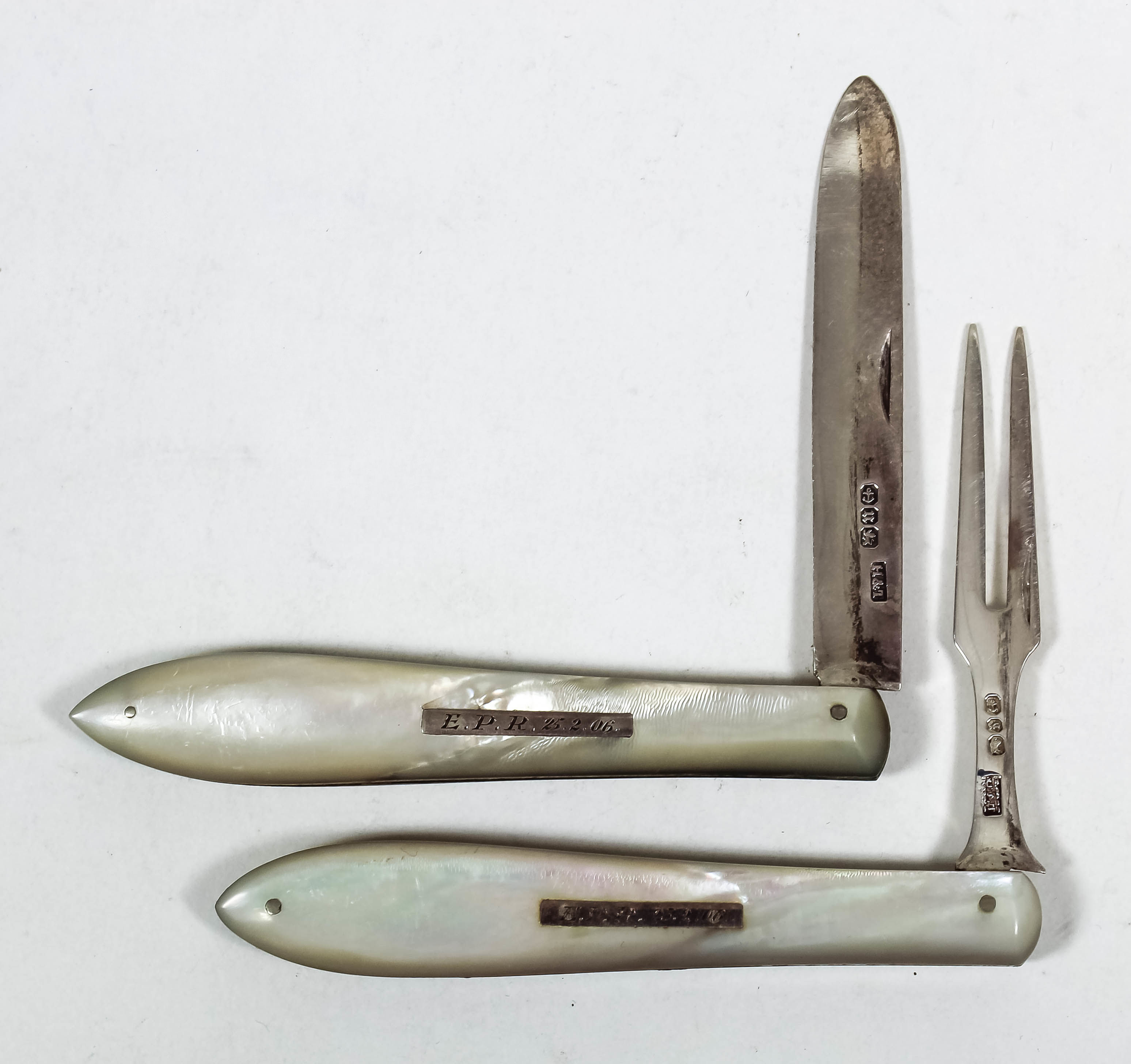 A late Victorian silver bladed and mother of pearl handled pocket fruit knife and fork, the plain