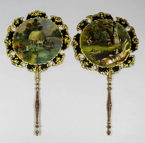 A pair of 19th Century black papier mache hand screens of shaped outline painted with scenes of