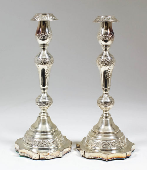 A pair of George V silver pillar candlesticks with reeded sconces, the knopped stems cast with