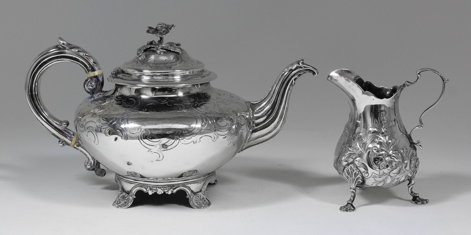 A Victorian silver circular teapot engraved with scroll and floral ornament, with floral cast