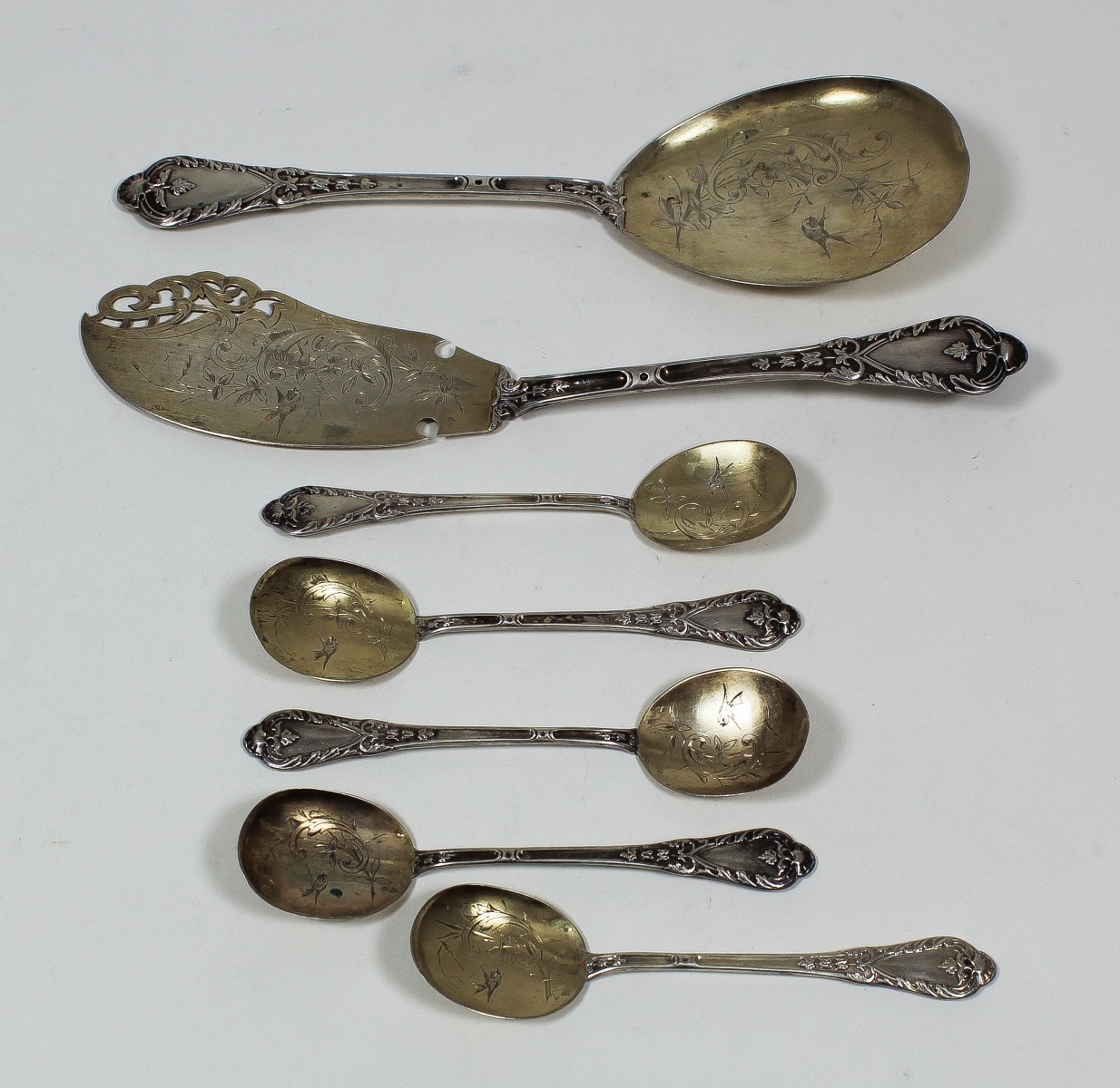 A late 19th Century Spanish silvery gilt metal part cutlery service with engraved blades and leaf