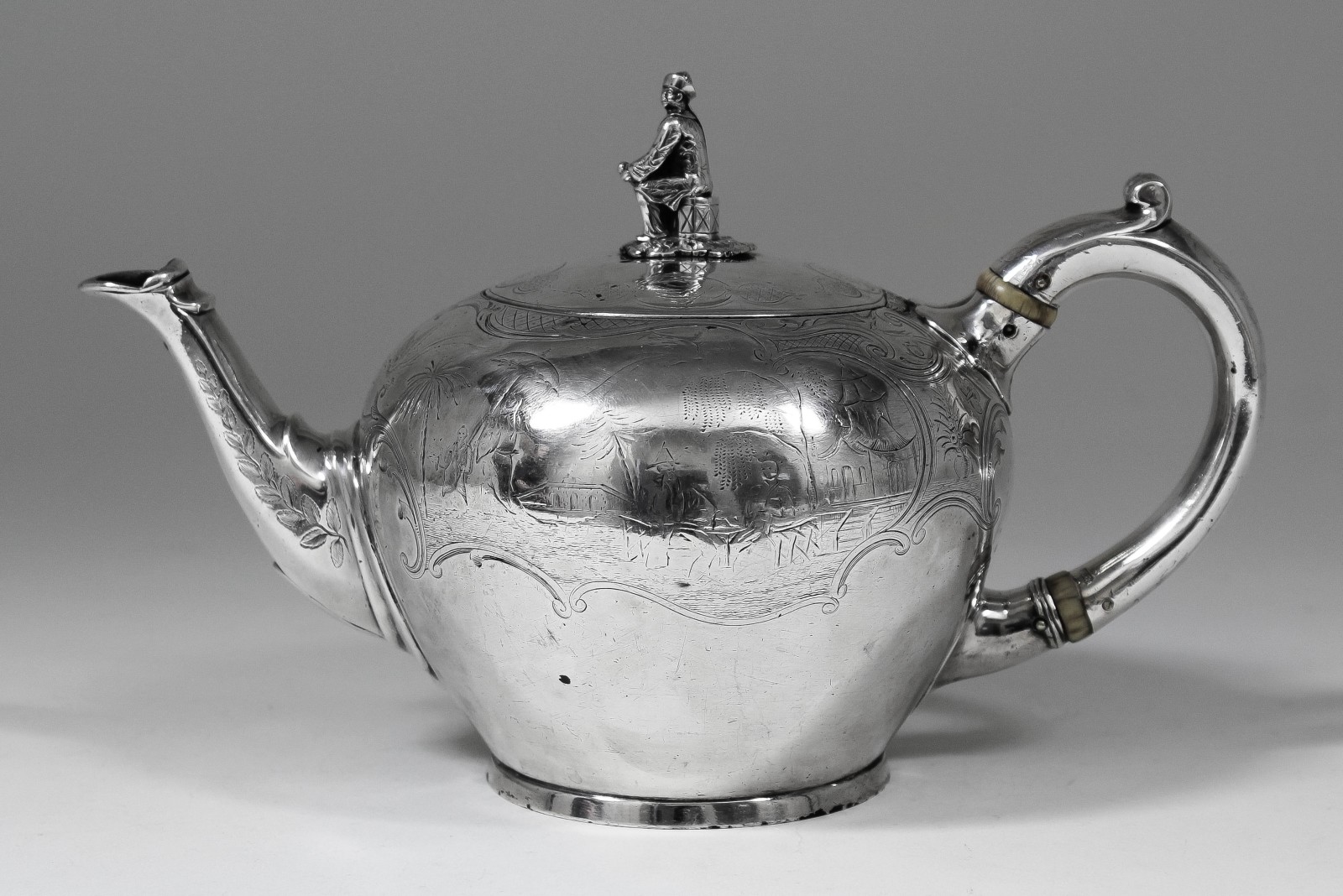 An early Victorian silver spherical teapot, the whole engraved with chinoiseries with figural