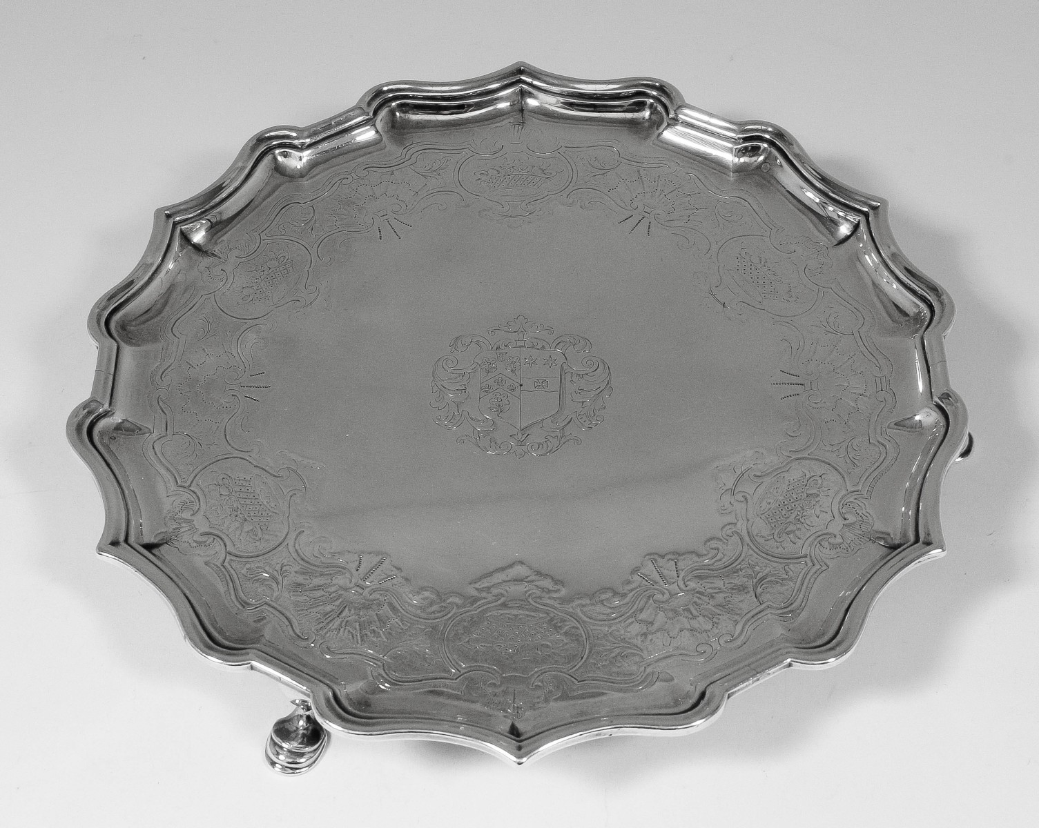 A George II silver circular salver with shaped and moulded rim, engraved with banding conforming to