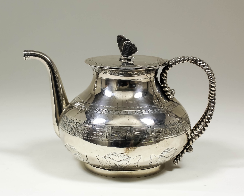 A Victorian silver teapot, the bulbous body engraved with Vetruvian scroll and leaf motifs, with