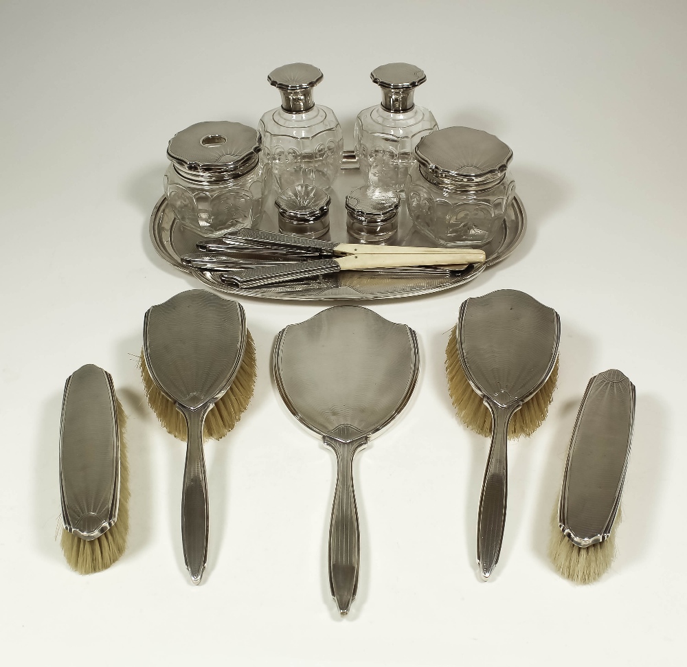 A George V silver, silver backed and silver topped twenty-two piece dressing table/manicure set with