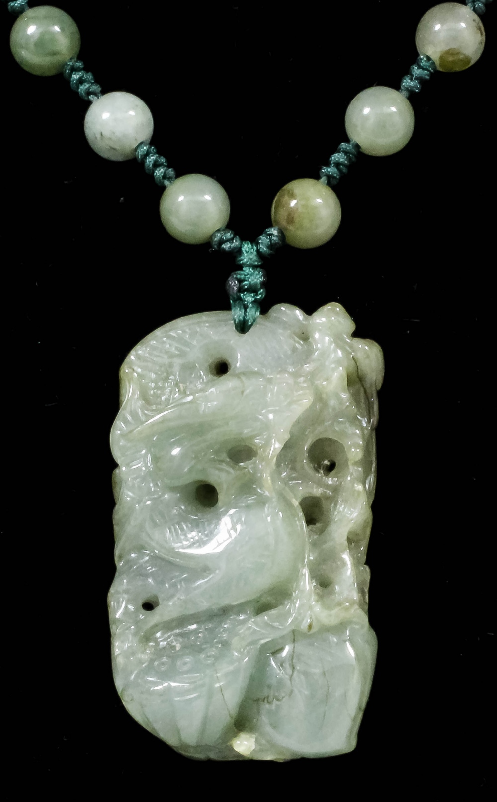 A single strand of pale celadon green jadeite beads strung on silk, 560mm overall, hung with an