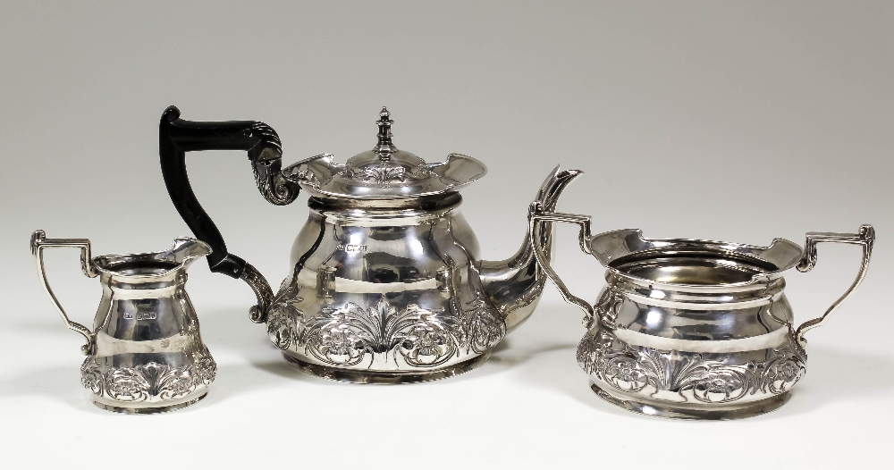 An Edward VII silver circular three piece tea service with angular handles, the bulbous bodies