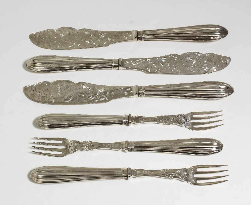 A set of twelve Victorian silver fish knives and forks with reeded handles and blades engraved