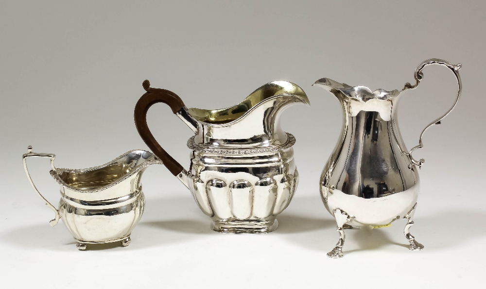 A William IV silver baluster shaped cream jug with shaped rim, on three splayed paw feet, 6ins high,