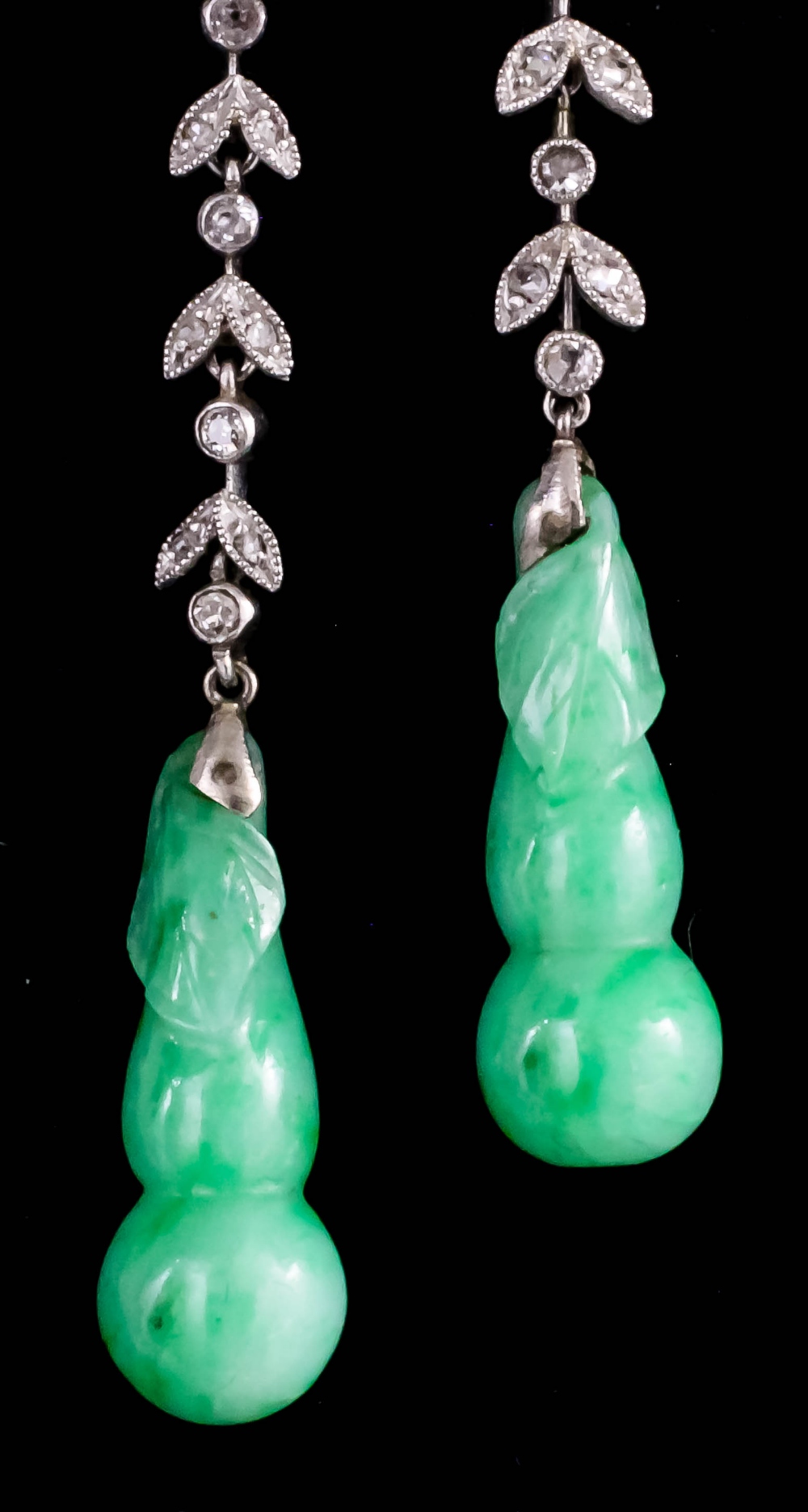 A pair of 1920s silvery coloured metal mounted mottled green jade and diamond set pendant drop