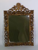 LATE NINETEENTH CENTURY FLORENTINE STYLE PIERCED GILTWOOD WALL MIRROR,  the oblong bevel edged