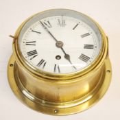 BRASS SHIPS CLOCK, typical form, with 6"" enamelled Roman dial, 8 1/2"" (21cm) diameter overall