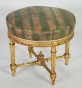 FRENCH CARVED GILTWOOD FOOTSTOOL,  the circular stuff over seat covered in green striped fabric,