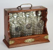 VICTORIAN OAK THREE BOTTLE TANTALUS, with electroplated mounts, of typical form with mirror glazed