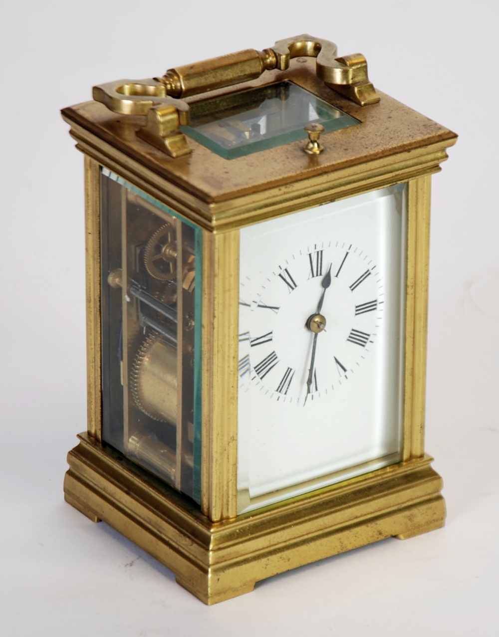 EARLY 20TH CENTURY BRASS GOING STRIKING CARRIAGE CLOCK, the white enamelled Roman mask (cracked)