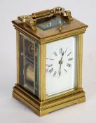 EARLY 20TH CENTURY BRASS GOING STRIKING CARRIAGE CLOCK, the white enamelled Roman mask (cracked)