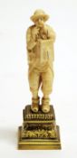 NINETEENTH CENTURY FRENCH DIEPPE CARVED IVORY FIGURE OF A STREET ENTERTAINER,  with caged bird, on