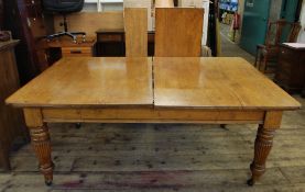 EARLY TWENTIETH CENTURY OAK  WIND-OUT EXTENDING DINING TABLE,  with two extra leaves, the  rounded