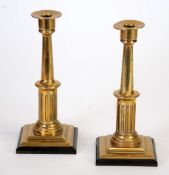 PAIR OF EARLY 20TH CENTURY POLISHED BRASS CANDLESTICKS each with circular sconce above a two part,