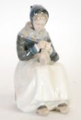 A ROYAL COPENHAGEN FIGURE OF A SEATED AMAGER LADY KNITTING, 9"" (22.8cm) high, printed marks