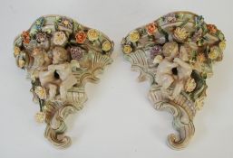 A PAIR OF MODERN GERMAN POTTERY WALL POCKETS, each moulded with a pair of embracing cherubs and