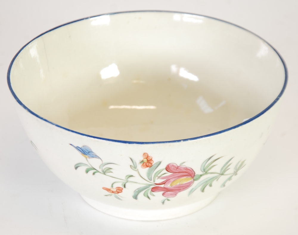 ANTIQUE ENGLISH CREAM WARE POTTERY SLOPS BOWL, painted in colours with flowers, beneath a blue