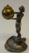 A WMF ART NOUVEAU SILVERED AND BRASS FIGURAL TABLE CIGARETTE LIGHTER, modelled as a lady holding