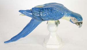 MODERN ROYAL DUX PORCELAIN MODEL OF A BLUE PARROT,  modelled perched on a plinth base, 8 1/2"" (21.