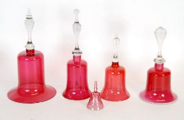 FOUR NINETEENTH CENTURY CRANBERRY GLASS BELLS, including one with vaseline glass rim AND A SMALLER