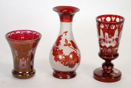 THREE NINETEENTH CENTURY RUBY STAINED AND ENGRAVED GLASS VASES, two with near matching design of