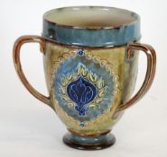 EARLY TWENTIETH CENTURY ROYAL DOULTON MOULDED POTTERY THREE HANDLED TYG, footed, tapering form with