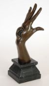 AFTER MILE, PATINATED BRONZE HAND AND EAR SCULPTURE, raised on a veined black slate pedestal base,