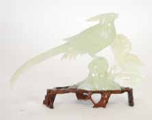 MODERN ORIENTAL CARVED GREEN HARDSTONE MODEL OF AN EXOTIC BIRD, modelled perched on leafy bough, 6