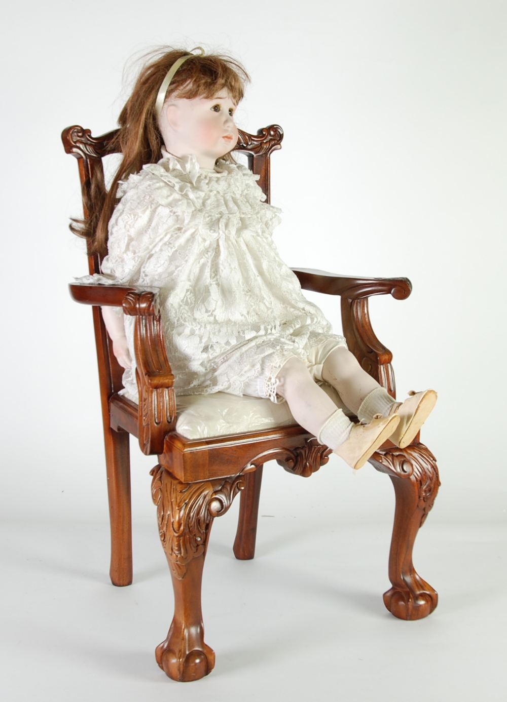 A MODERN BISQUE HEADED GIRL CHARACTER DOLL, with brown glass eyes, natural brown wig, fabric body