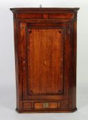 EARLY NINETEENTH CENTURY OAK AND MAHOGANY CROSSBANDED CORNER CUPBOARD, the moulded cornice above a