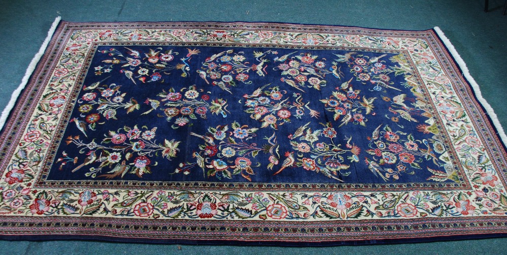 LARGE EASTERN RUG, with a large repeat pattern of exotic birds on flowering shrubs on a midnight