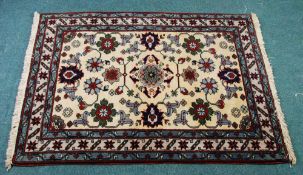 EASTERN RUG with heraldic design on an off white field, off white and floral meander border with