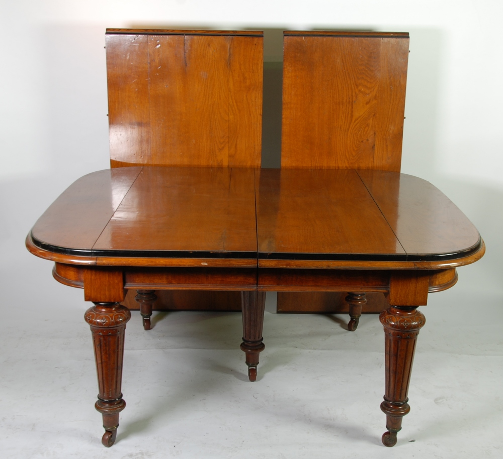VICTORIAN HEAVY OAK WIND-OUT EXTENDING DINING TABLE, with five legs and four extra leaves, the