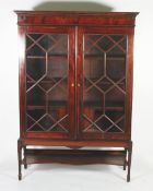 NINETEENTH CENTURY LINE INLAID MAHOGANY BOOKCASE on later stand, the moulded cornice above a flame